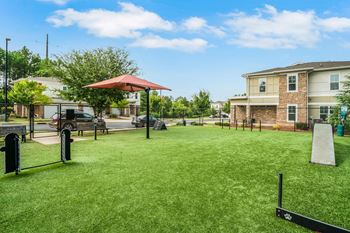 A Playground With a Slide and a Red Canopy at The Aster Apartments, Cary